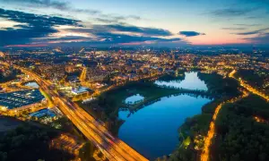 Nocny widok na miasto z lotu ptaka, oświetlona autostrada i trzy połączone jeziora tworzą malowniczą dolinę trzech stawów.