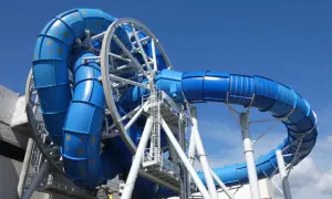 Aquapark Reda: niebieska zjeżdżalnia z rekinami, wirująca konstrukcja z rur, podniebna przygoda.