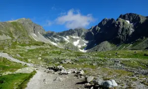 Kamienista ścieżka prowadzi przez zieloną dolinę w Tatrach Słowackich. Idealne tatry słowackie szlaki dla średnio zaawansowanych, z widokiem na skaliste szczyty.