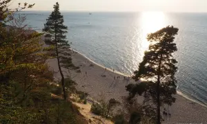 Zachód słońca nad Bałtykiem, złocący piaszczystą plażę i majestatyczne klify na wyspie Wolin.