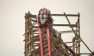 Ludzie na kolejce górskiej w Energylandii z ekscytacją zjeżdżają po drewnianej konstrukcji.