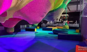 Kolorowa, pleciona konstrukcja w Funzeum Gliwice. Miękkie siedziska i podłoga w odcieniach niebieskiego i zieleni tworzą przestrzeń do zabawy.