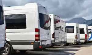 Białe busy czekają na pasażerów. Planujesz wycieczkę do Doliny Chochołowskiej? Zobacz, dolina chochołowska jak dojechać z Zakopanego.