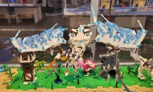 Lodowy smok w muzeum LEGO w Warszawie walczy z robotem na tle miniaturowej wioski.