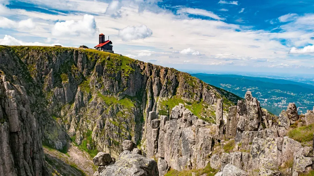 Szrenica góruje nad Śnieżnymi Kotłami, gdzie skalne urwiska i zielone zbocza tworzą majestatyczny krajobraz.