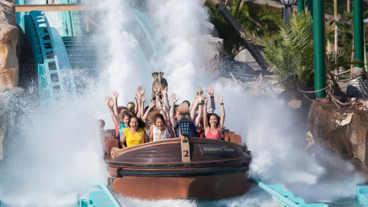 Ludzie na łodzi w parku rozrywki Niemcy, Europa-Park, krzyczą z radości, gdy wpadają w wodę.