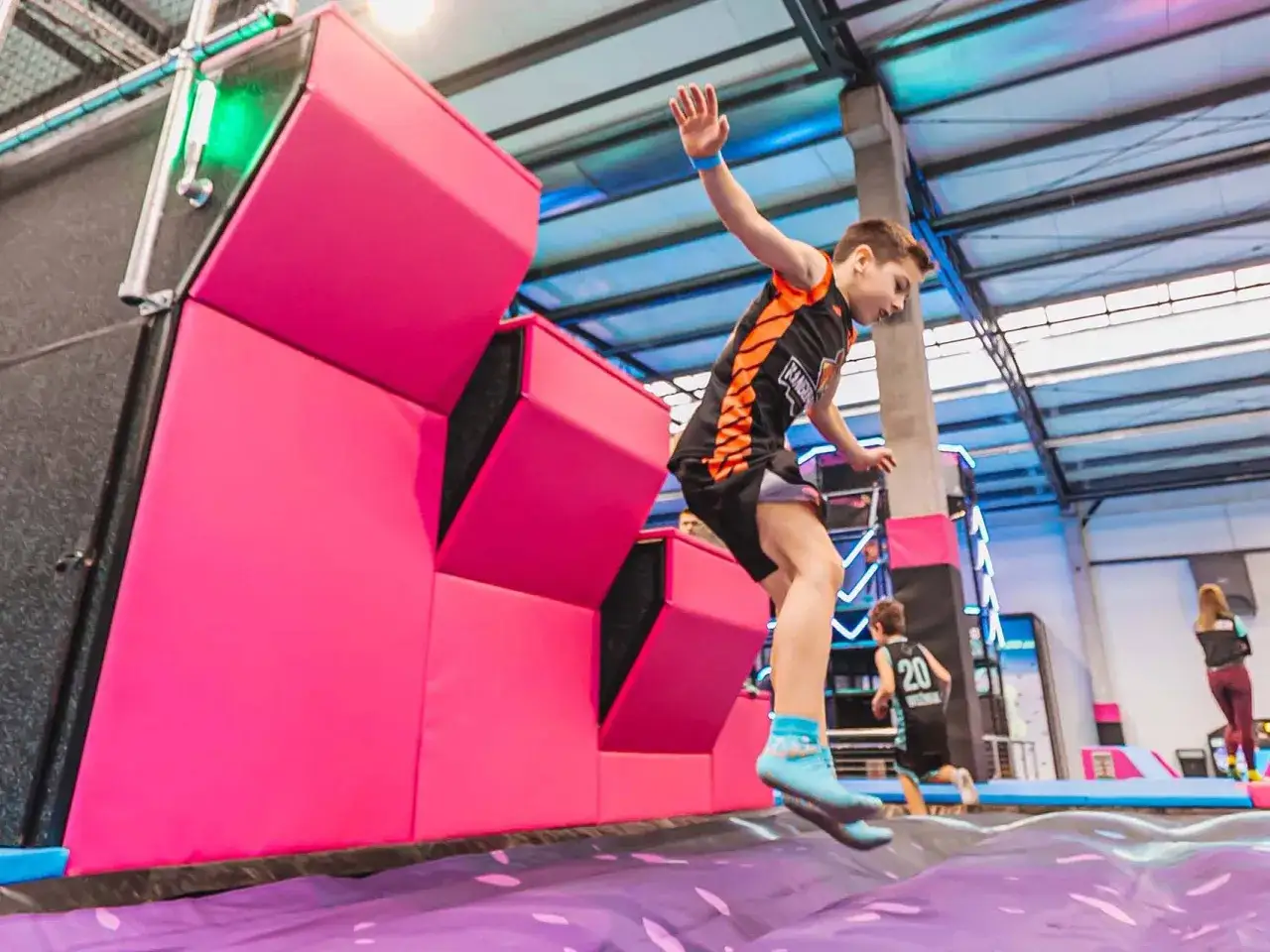Chłopiec skacze na trampolinie w parku rozrywki. To świetny game time gorzow dla całej rodziny!