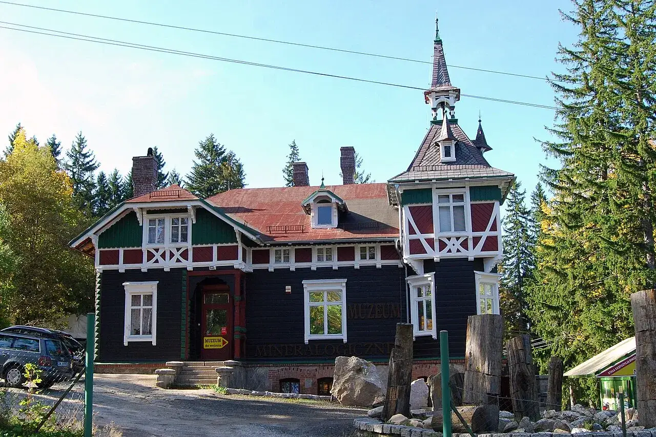 Muzeum Mineralogiczne w Szklarskiej Porębie, zabytkowy budynek z wieżyczką, otoczony drzewami.