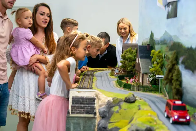 Rodzina podziwia miniaturową wioskę, szukając atrakcji dla dzieci w Jeleniej Górze.
